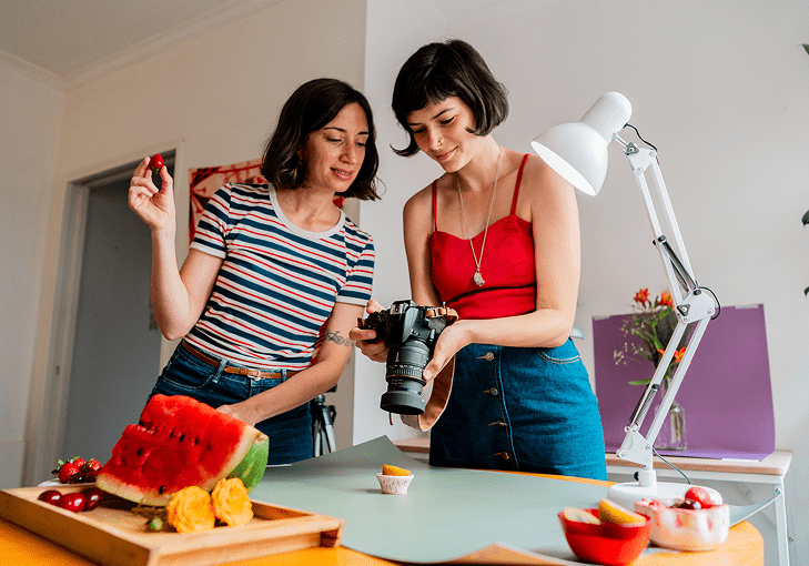 Women capturing food photography scene